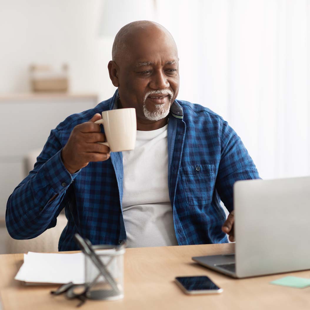 Man working on a laptop with a cup of coffee