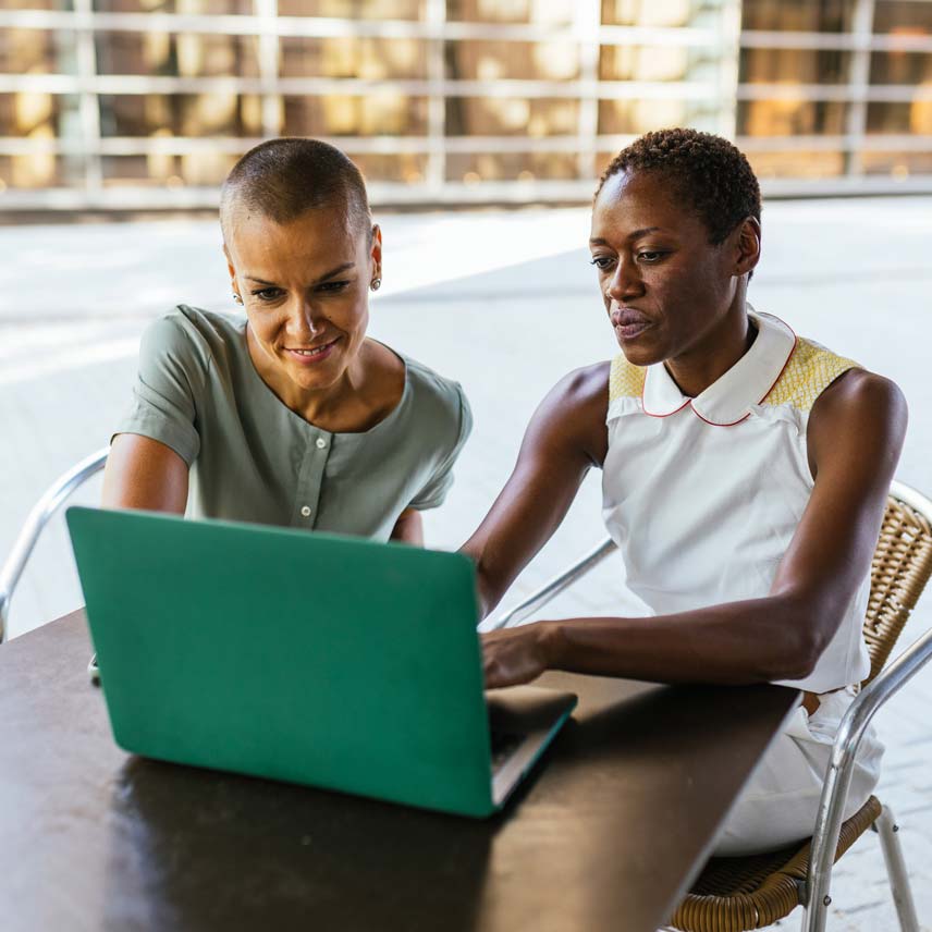 Two women working together on a laptop