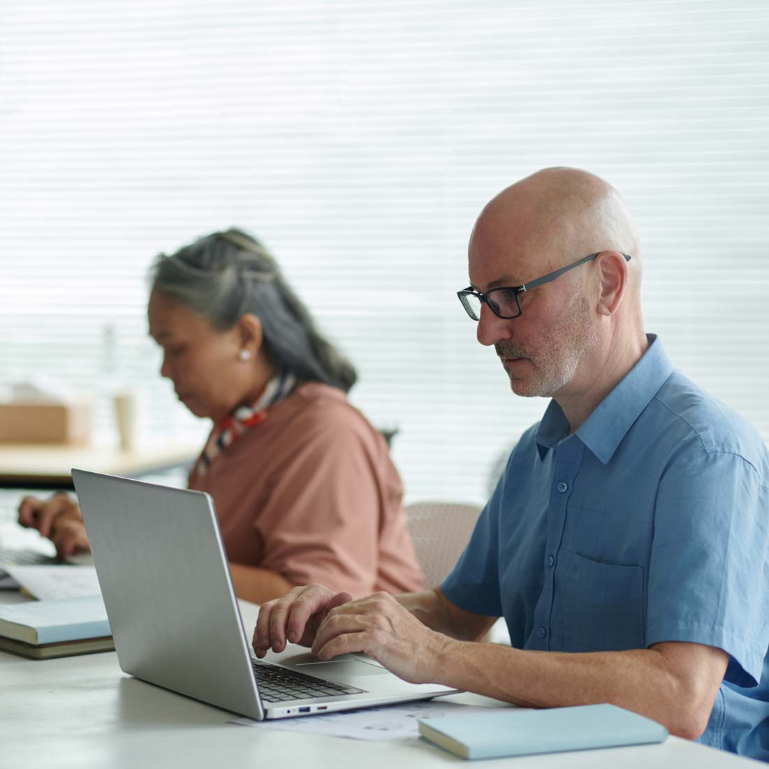 Two adults working together at a laptop